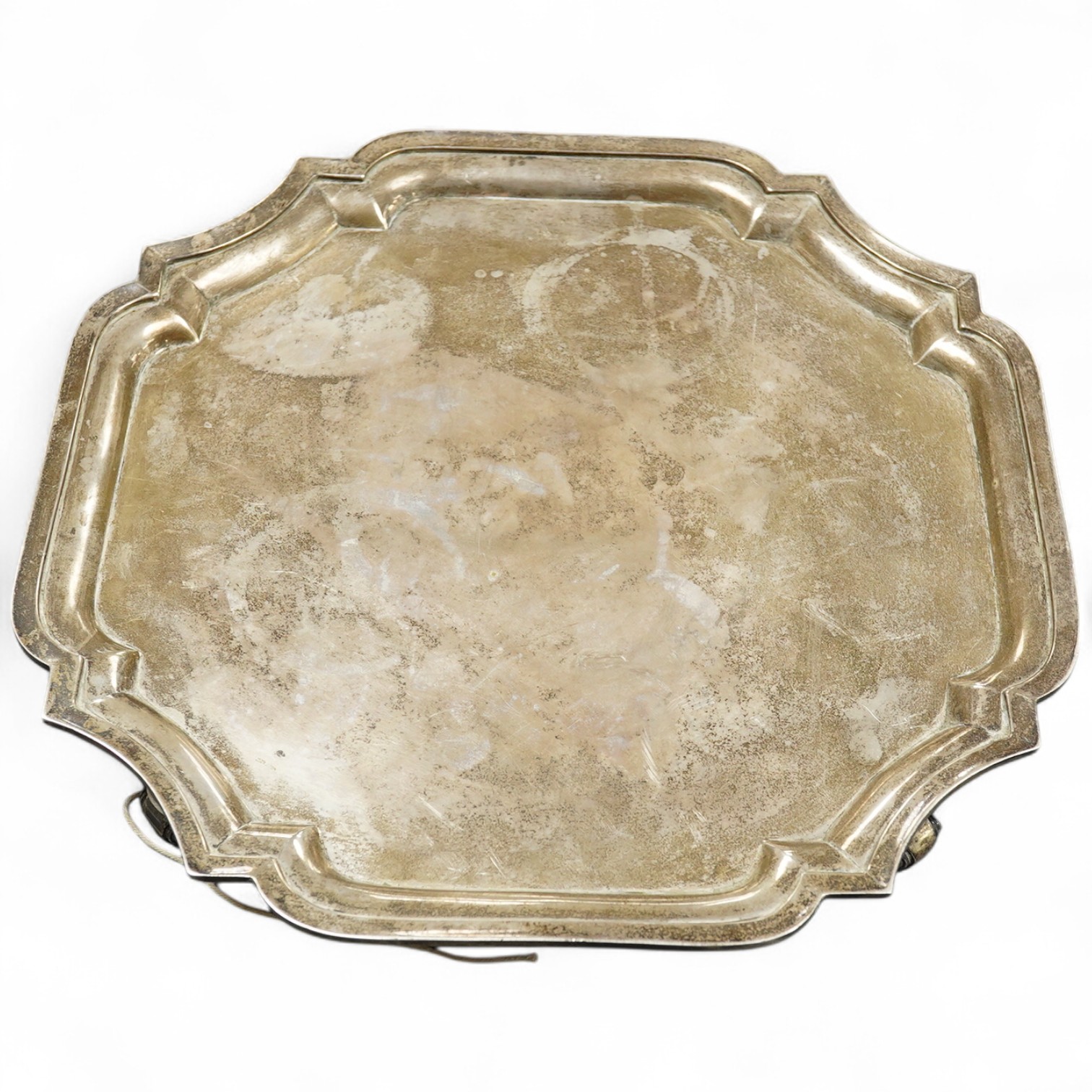An early 20th century Indian white metal salver (tests as silver) by Hamilton & Co of Calcutta, of shaped square form, with inswept corners, on four scroll feet, 32.9cm, 38.7oz.